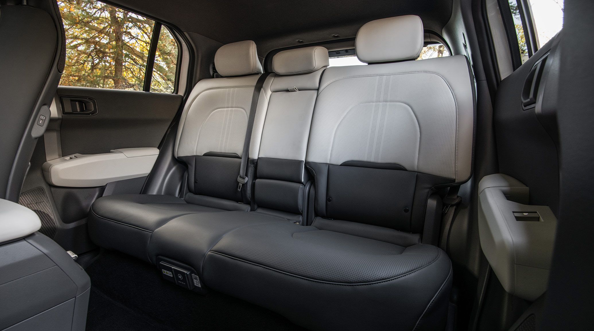 Interior view of the 2027 Kia EV3 electric SUV showing the spacious back seating area, including two-tone styling and headrests.
