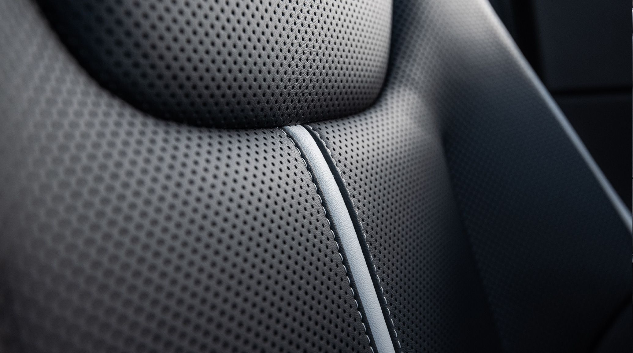 Interior extreme close-up of the perforated seat fabric and contrast stitching inside the 2026 Kia EV6 electric CUV GT-Line AWD trim.