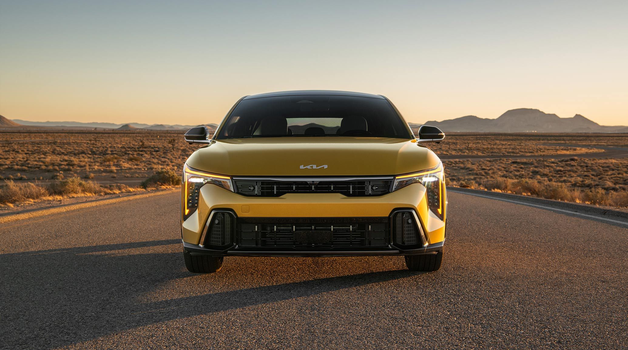 Exterior Standing Front Shot of the 2026 K4 Hatchback GT-Line Turbo in Gold Yellow, highlighting the LED Cube Projectors