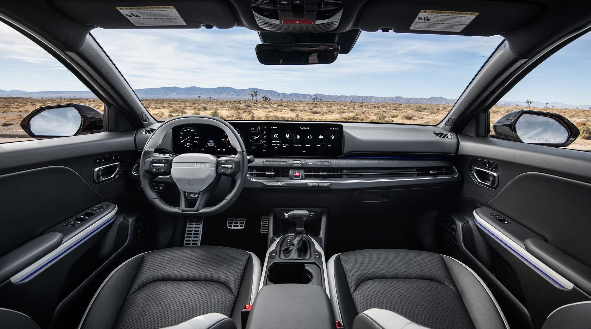 A front interior shot of the 2026 K4 Hatchback GT-Line Turbo showing the steering wheel, dashboard, and infotainment display with aluminum pedals and heated and ventilated front seats.