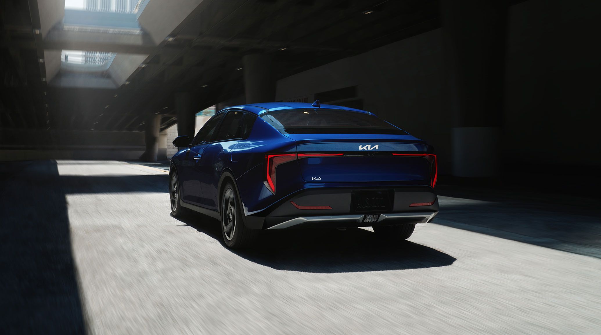 Rear view of the 2026 Kia K4 sedan EX trim in blue, featuring the LED taillights