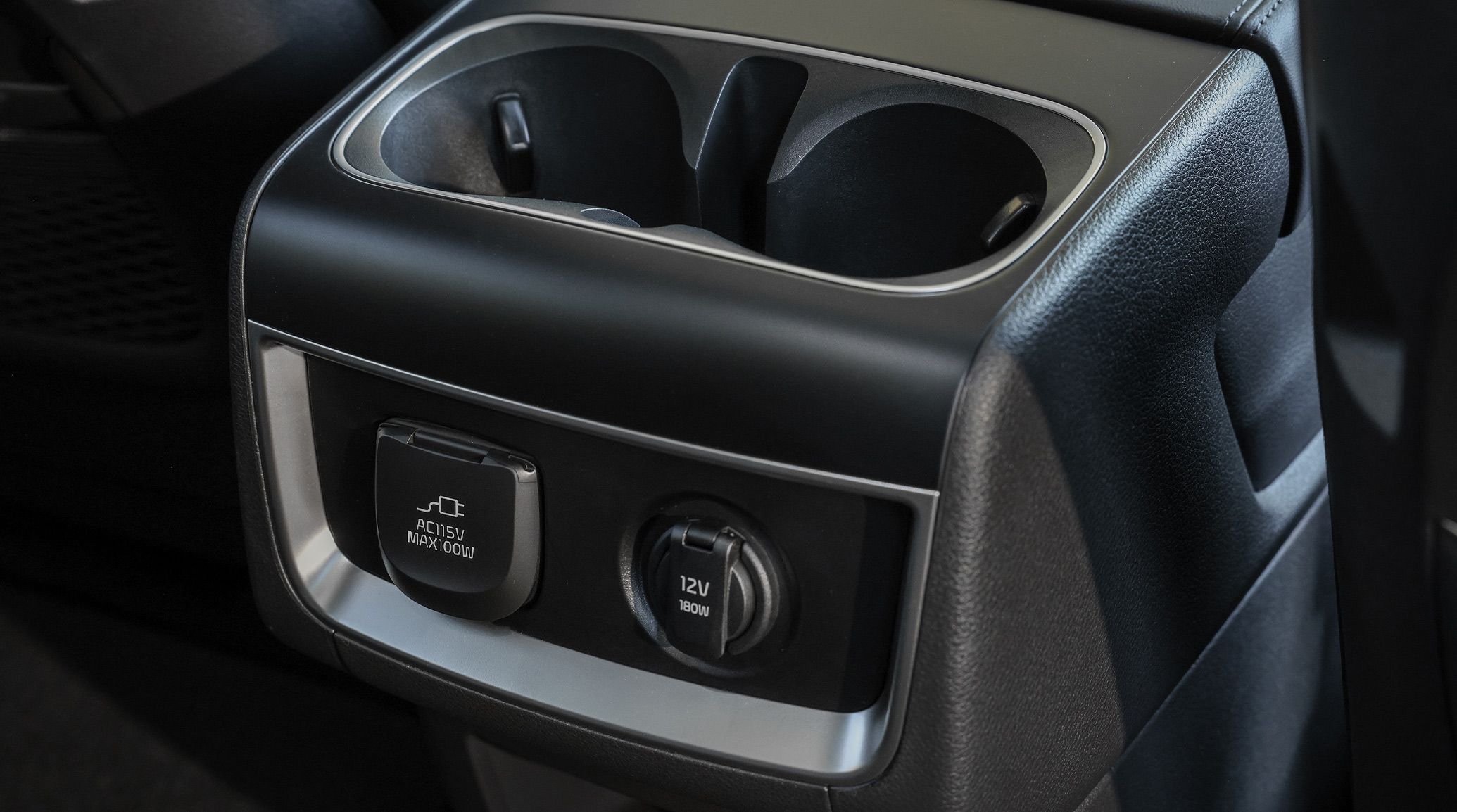 The 2027 Kia Carnival MPV Minivan black interior, featuring the 2nd-row cupholders and multiple power options.