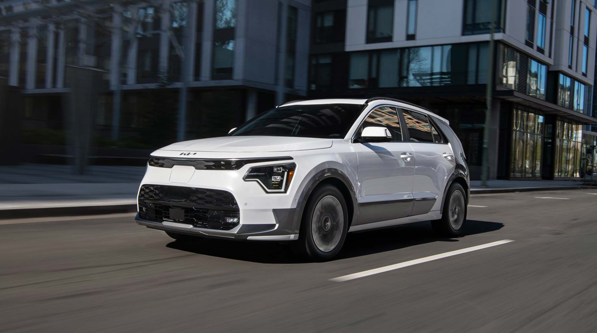 2026 Kia Niro EV in white driving on a city road, front three-quarter view