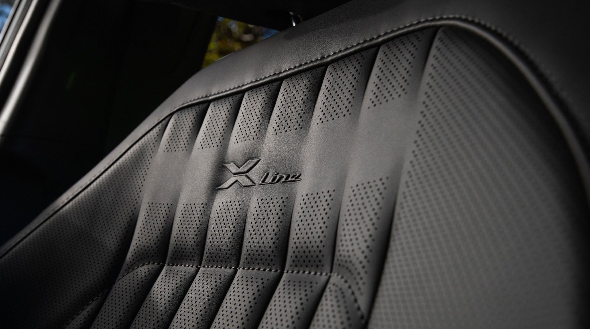 Close-up of the 2027 Kia Seltos X-Line SX AWD front seat featuring X-Line embossed trim with black SynTex upholstery and premium textured detailing.
