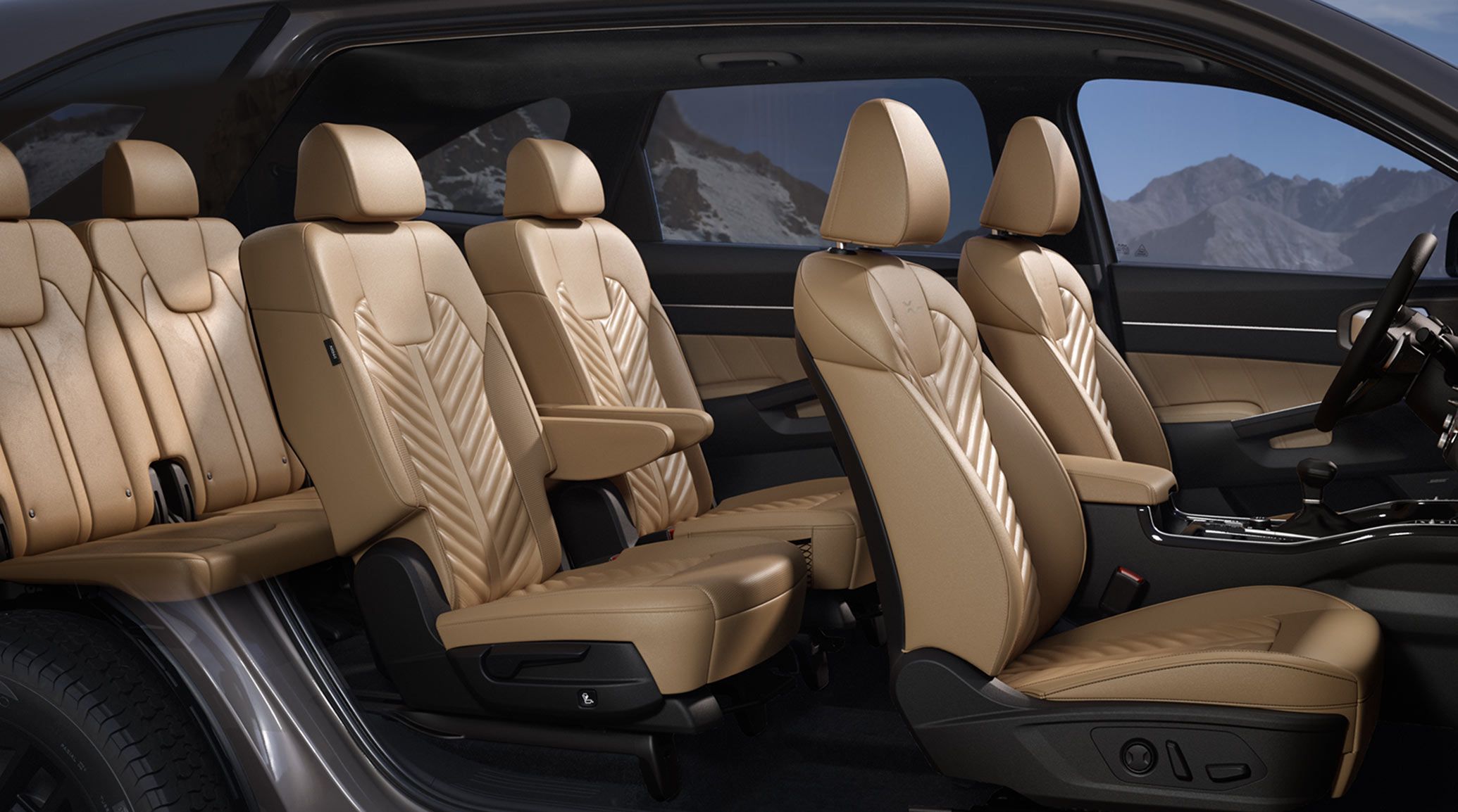 A side view of the 2027 Kia Sorento highlighting its brown three-row seating interior. The image emphasizes the spacious cabin, second-row captain’s chairs, and 6-passenger seating, with mountains visible through the windows.