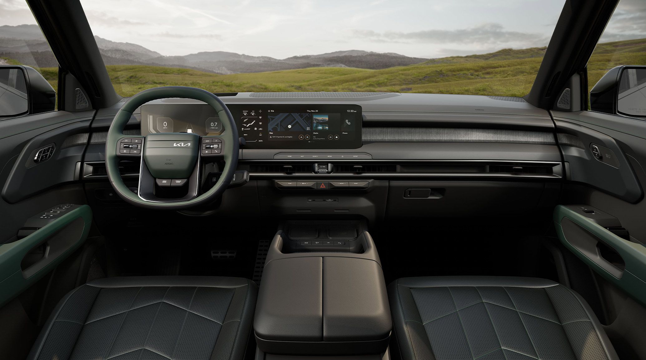 An interior view of the 2027 Kia Telluride Hybrid in black with green details, highlighting the front seats, steering wheel, digital display, and center console with a grassy field and hills visible through the windshield.