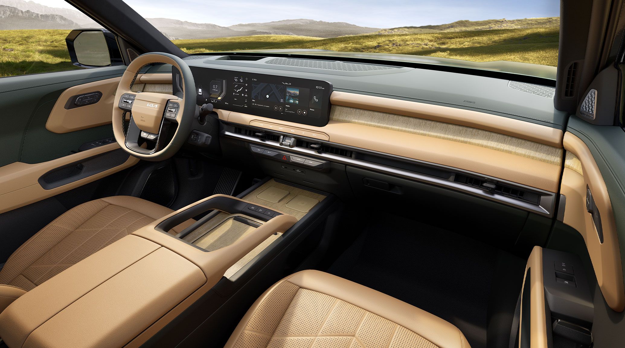 Interior view of the 2027 Kia Telluride featuring light brown interior with driver-side steering wheel, digital display, and center console, with a sunlit grassy landscape and distant mountains visible through the windshield.