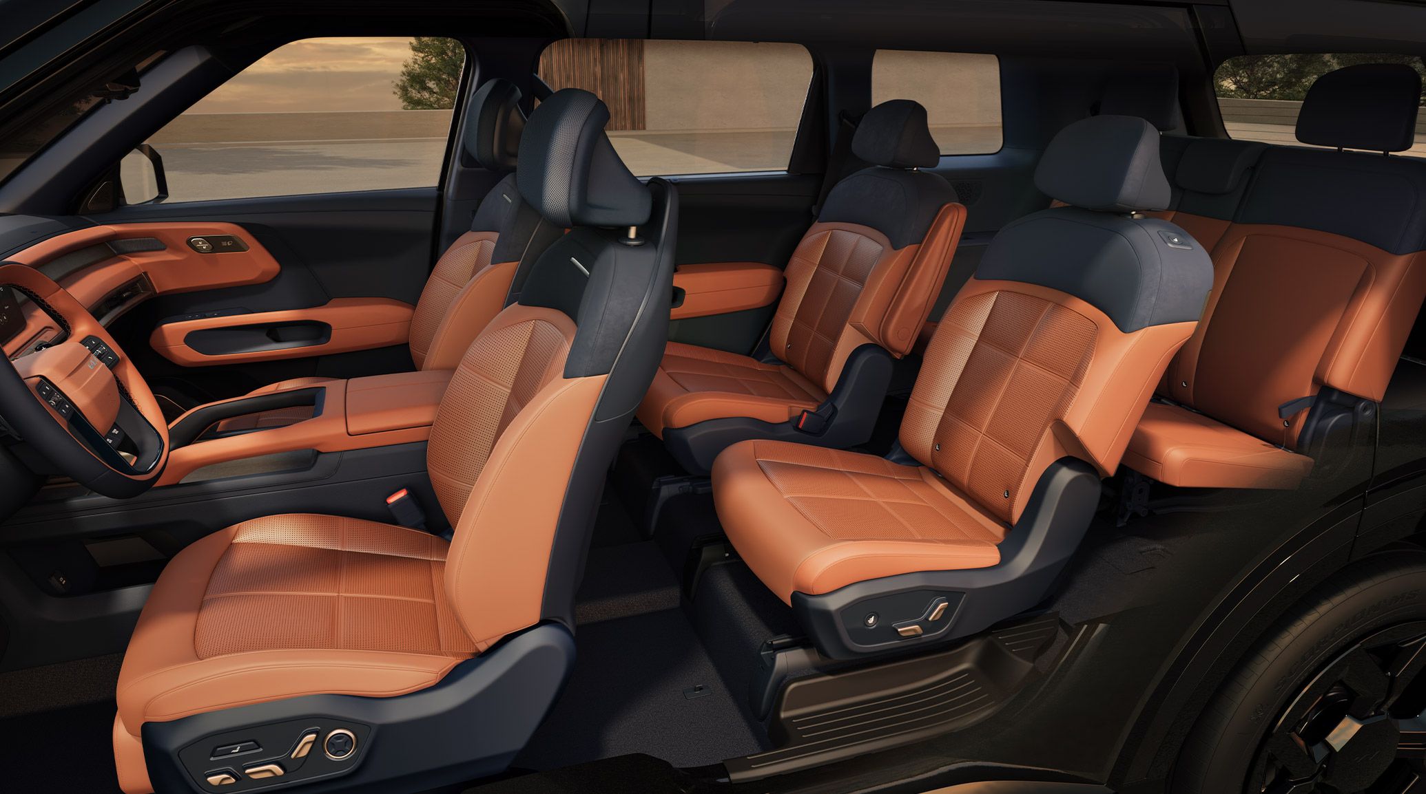 A side view of the 2027 Kia Telluride highlighting its red-and-navy three-row seating interior. The image emphasizes the spacious cabin, second-row captain’s chairs, and 7-passenger seating, with an outdoor setting visible through the windows.